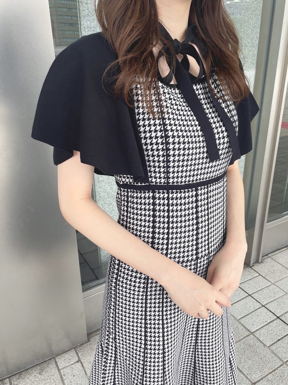 ブラック系のワンピース、ホワイト系のショルダーバッグ、ホワイト系のブーツを着用したレディースの夏コーディネートの5枚目の写真