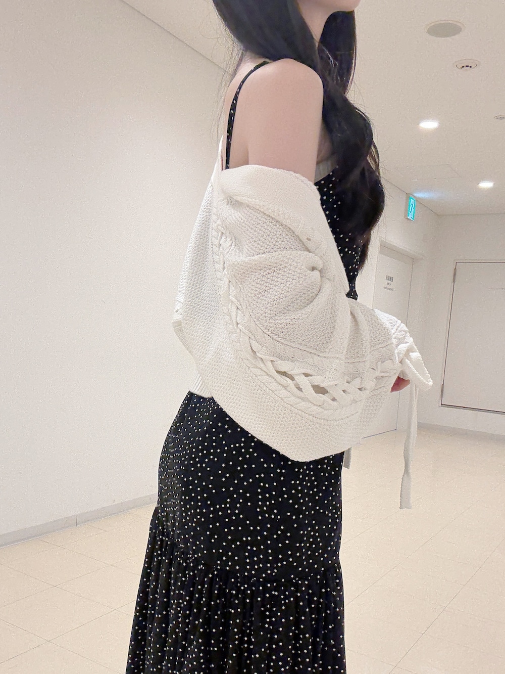 ブラック系のワンピース、ホワイト系のカーディガン/ボレロ、ホワイト系のパンプスを着用したレディースの秋コーディネートの6枚目の写真