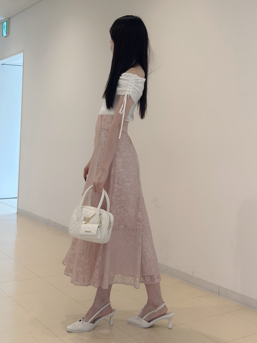 ホワイト系のニット/セーター、ブラック系のチューブトップ、ピンク系のスカートを着用したレディースの夏コーディネートの4枚目の写真