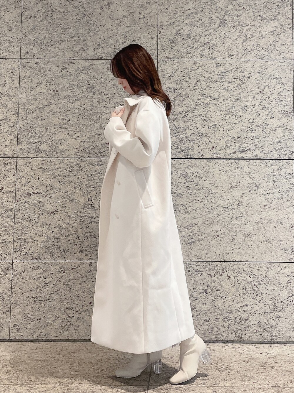 ホワイト系のステンカラーコート、ホワイト系のワンピースを着用したレディースの冬コーディネートの4枚目の写真