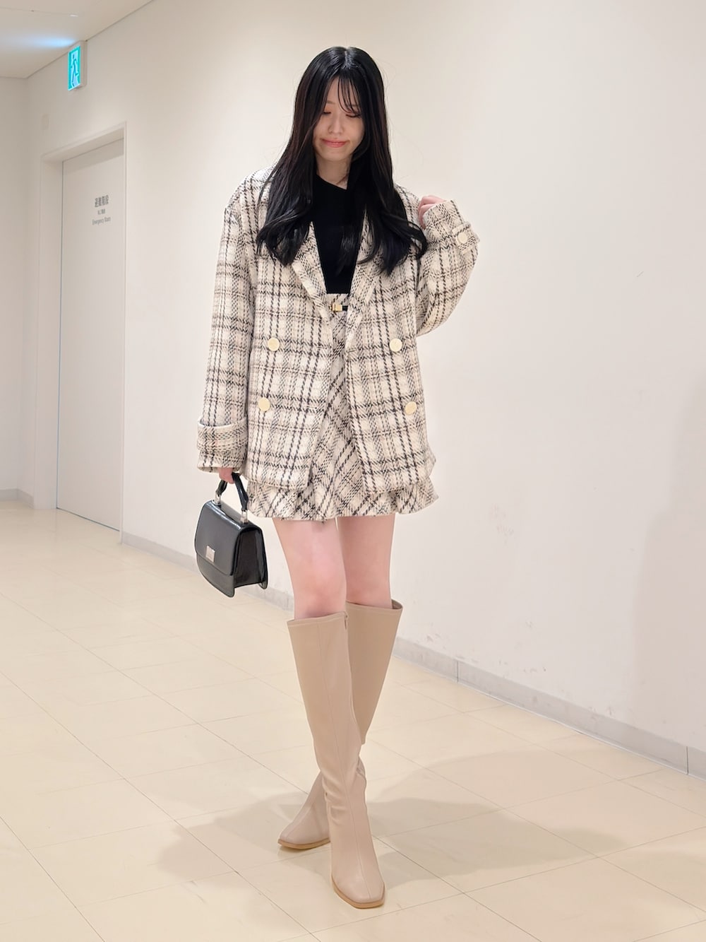 ブラック系のニット/セーター、ホワイト系のその他アウター、ホワイト系のその他パンツを着用したレディースの秋コーディネートの2枚目の写真