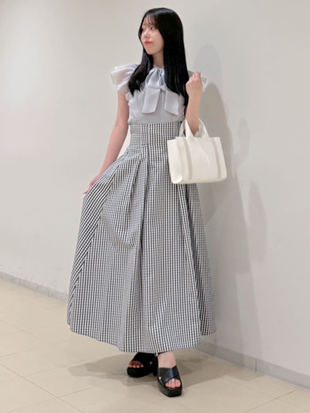 グレー系のニット/セーター、その他のスカート、ホワイト系のトートバッグを着用したレディースの春コーディネートの3枚目の写真