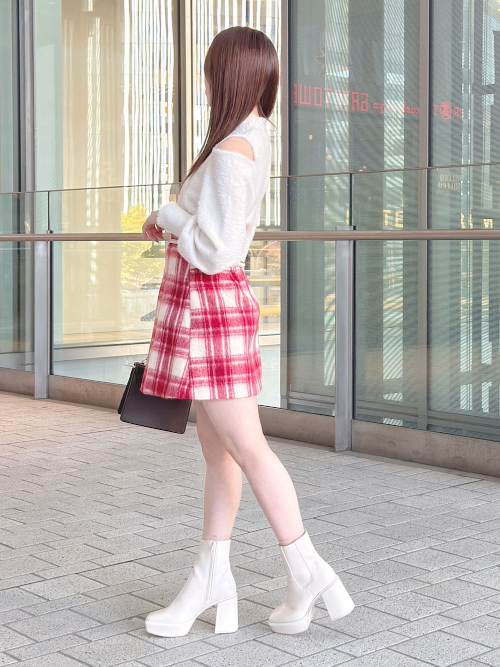 ブラウン系のチェスターコート、ホワイト系のニット/セーター、レッド系のその他パンツを着用したレディースの冬コーディネートの5枚目の写真