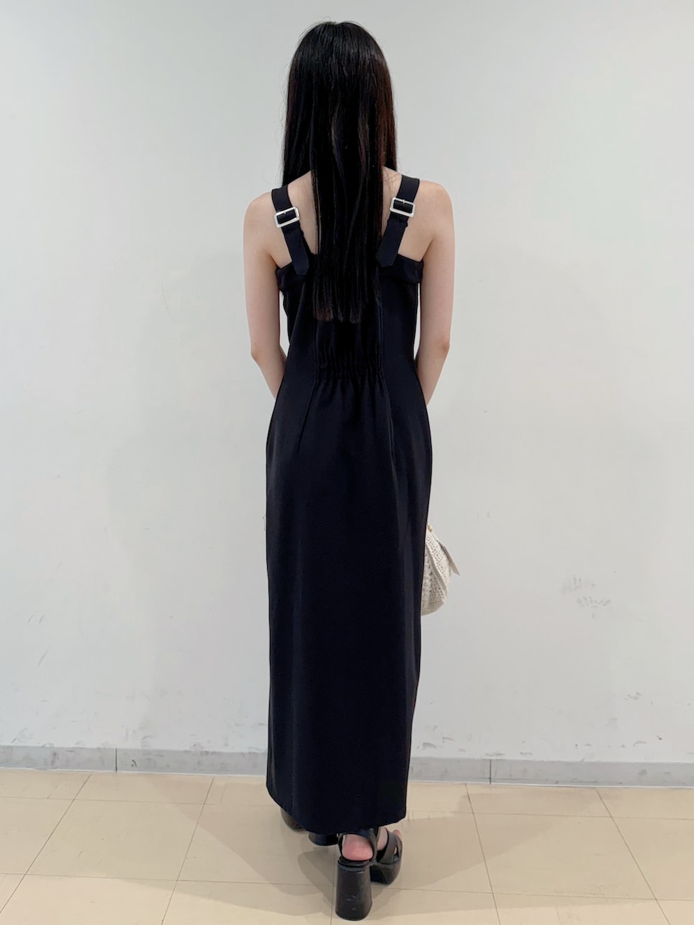 ブラック系のワンピース、ホワイト系のショルダーバッグ、ブラック系のサンダルを着用したレディースの夏コーディネートの5枚目の写真