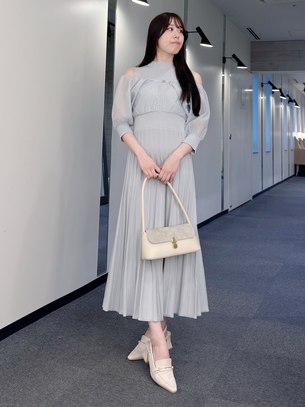 グレー系のワンピース、ホワイト系のハンドバッグ、ホワイト系のパンプスを着用したレディースの春コーディネートの5枚目の写真