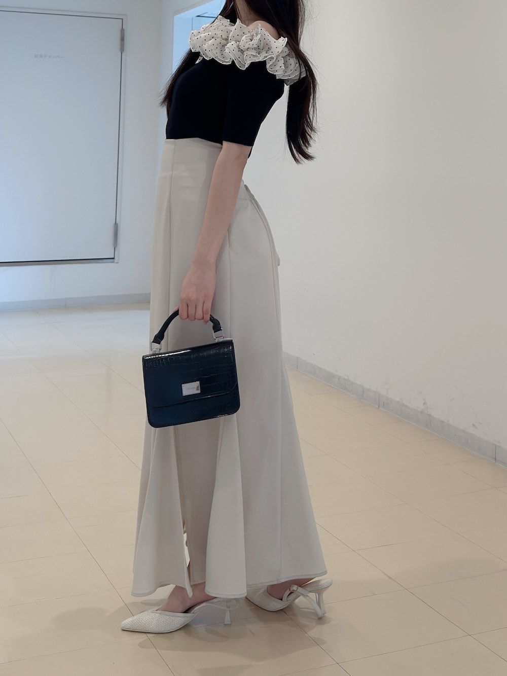 その他のニット/セーター、ホワイト系のスカート、ブラック系のハンドバッグを着用したレディースの春コーディネートの4枚目の写真