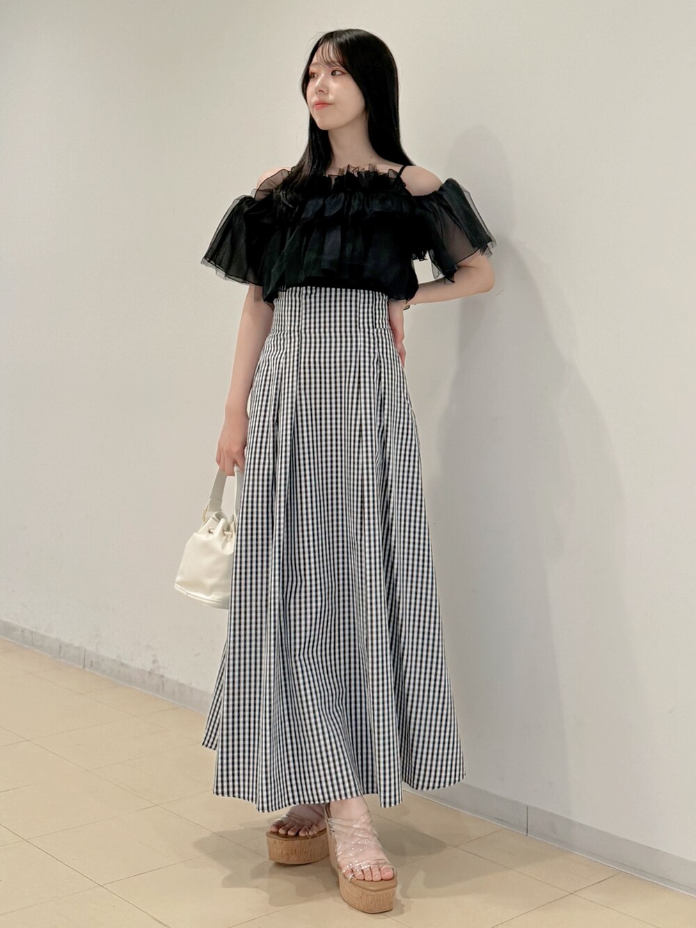 ブラック系のシャツ/ブラウス、その他のスカート、ホワイト系のハンドバッグを着用したレディースの春コーディネートの2枚目の写真