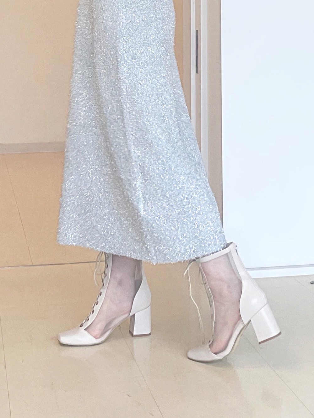 ホワイト系のカーディガン/ボレロ、シルバー系のワンピース、ブラック系のハンドバッグを着用したレディースの秋コーディネートの7枚目の写真