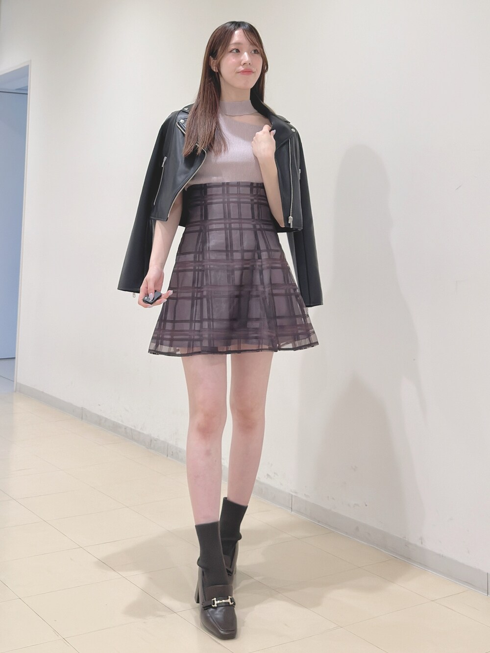 ブラック系のライダースジャケット、ベージュ系のニット/セーター、ブラウン系のその他パンツを着用したレディースの春コーディネートの3枚目の写真