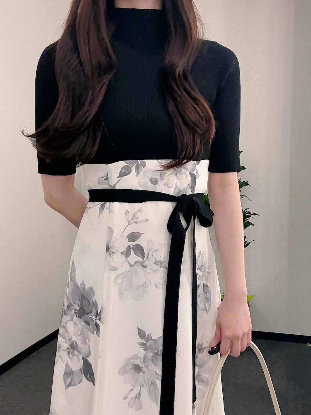 ブラック系のワンピース、ホワイト系のハンドバッグ、ホワイト系のパンプスを着用したレディースの春コーディネートの5枚目の写真