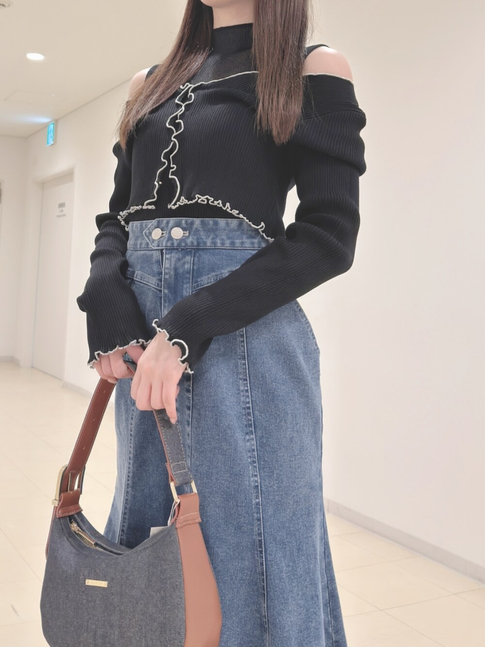 ホワイト系のブーツ、ブルー系のショルダーバッグ、ブラック系のニット/セーターを着用したレディースの春コーディネートの6枚目の写真