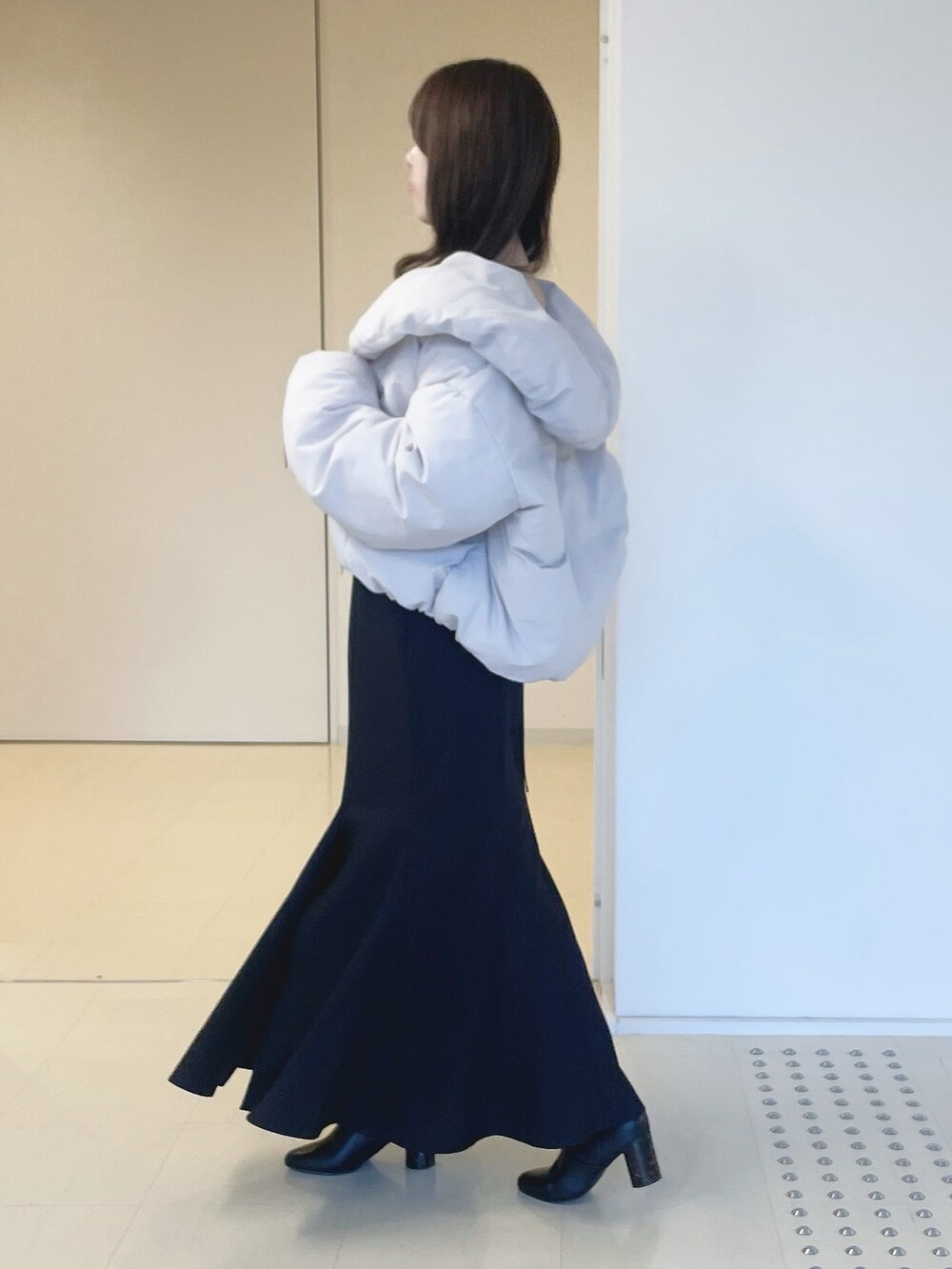 ブラック系のニット/セーター、ピンク系のダウンジャケット/コート、ブラック系のスカートを着用したレディースの冬コーディネートの3枚目の写真