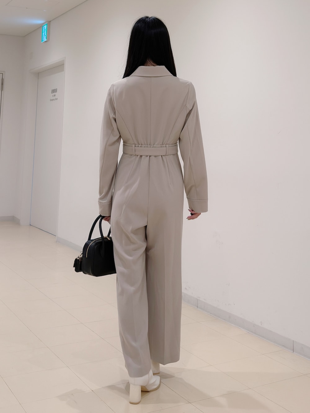 ベージュ系のつなぎ/オールインワン、ブラック系のハンドバッグ、ホワイト系のブーツを着用したレディースの秋コーディネートの4枚目の写真