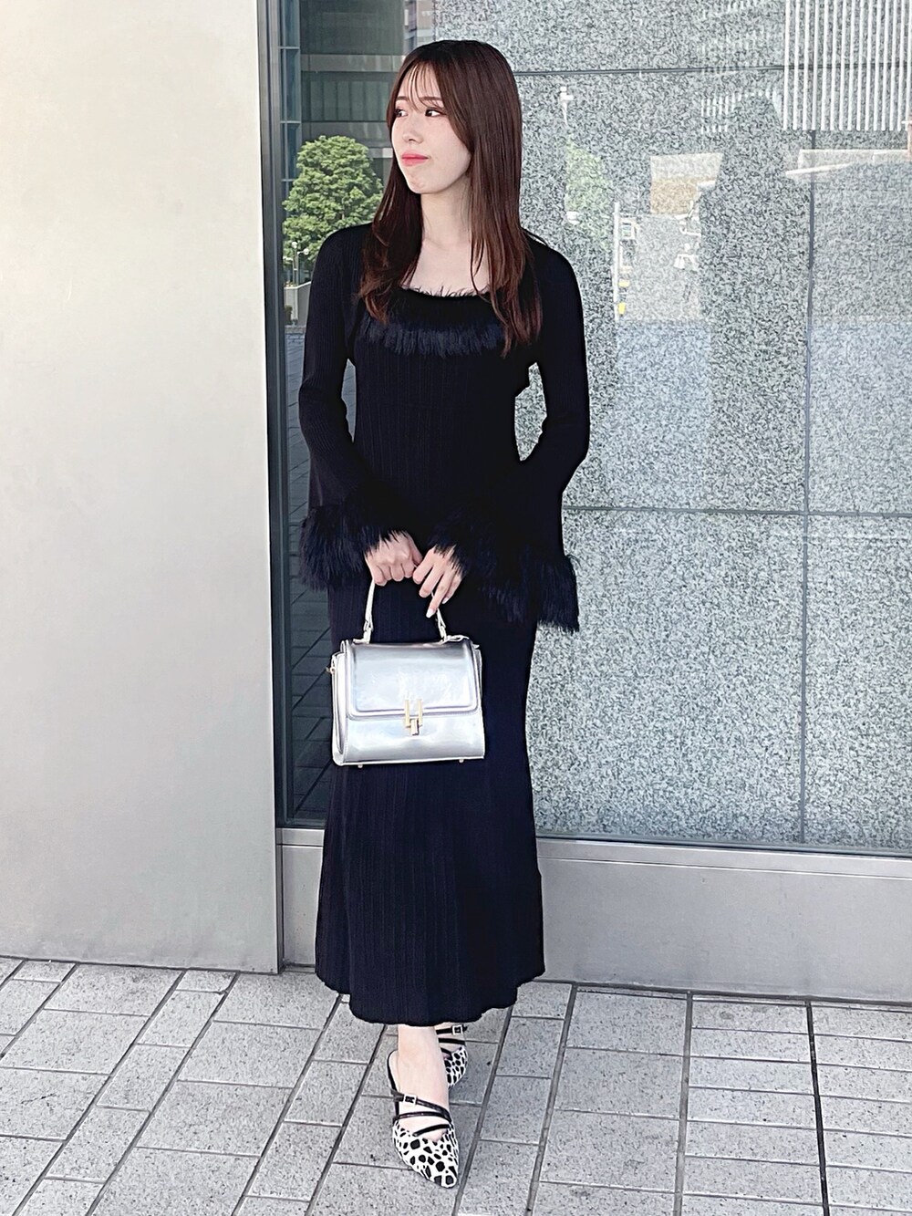 ブラック系のワンピース、シルバー系のハンドバッグ、その他のパンプスを着用したレディースの秋コーディネートの2枚目の写真