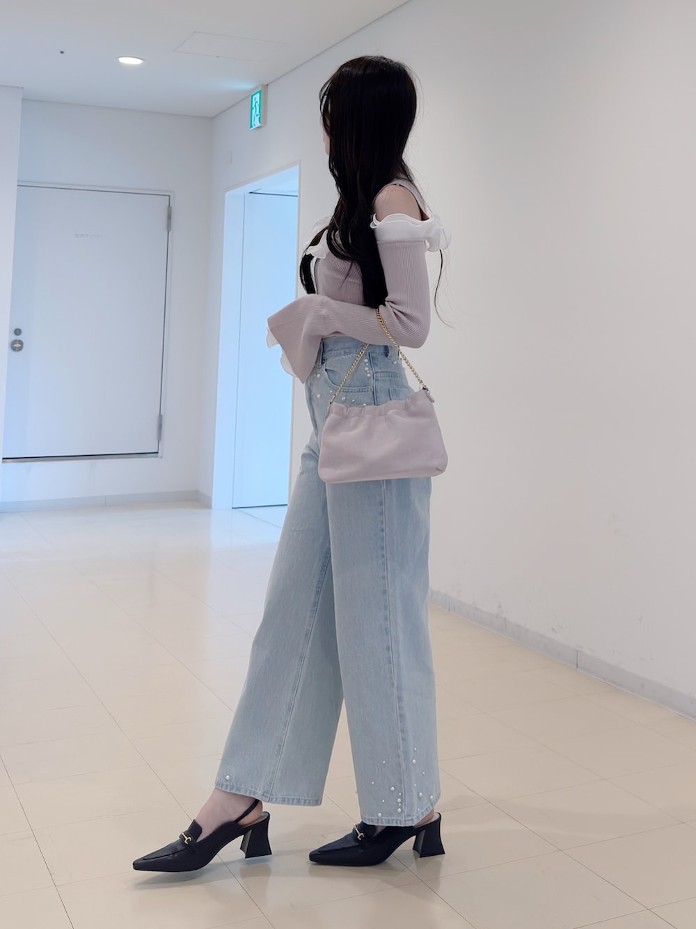 ベージュ系のニット/セーター、ブルー系のデニムパンツ、ピンク系のショルダーバッグを着用したレディースの春コーディネートの3枚目の写真