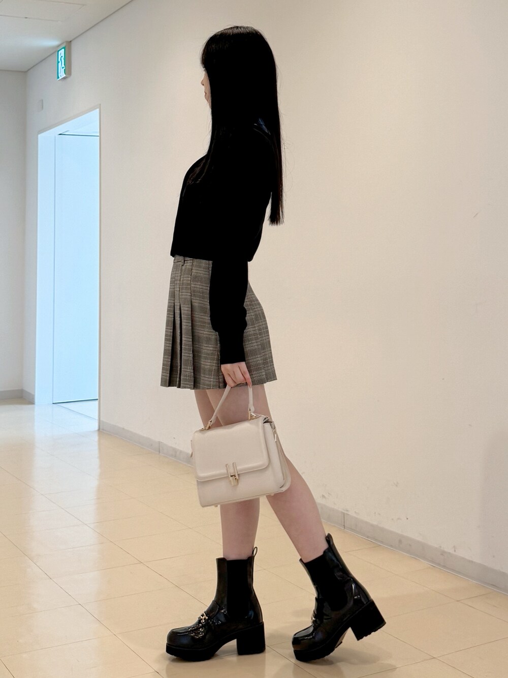 ブルー系のシャツ/ブラウス、グレー系のスカート、ホワイト系のハンドバッグを着用したレディースの夏コーディネートの4枚目の写真