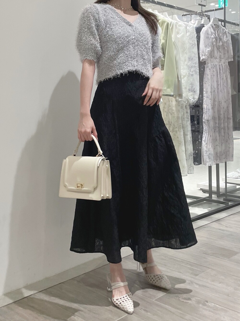 ブラック系のスカート、ホワイト系のパンプス、ホワイト系のカーディガン/ボレロを着用したレディースの冬コーディネートの4枚目の写真