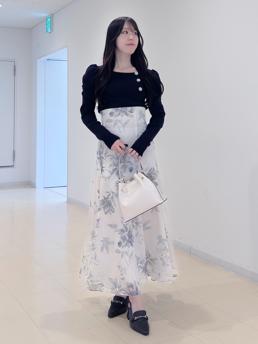 ブルー系のニット/セーター、ホワイト系のスカート、ホワイト系のショルダーバッグを着用したレディースの冬コーディネートの2枚目の写真