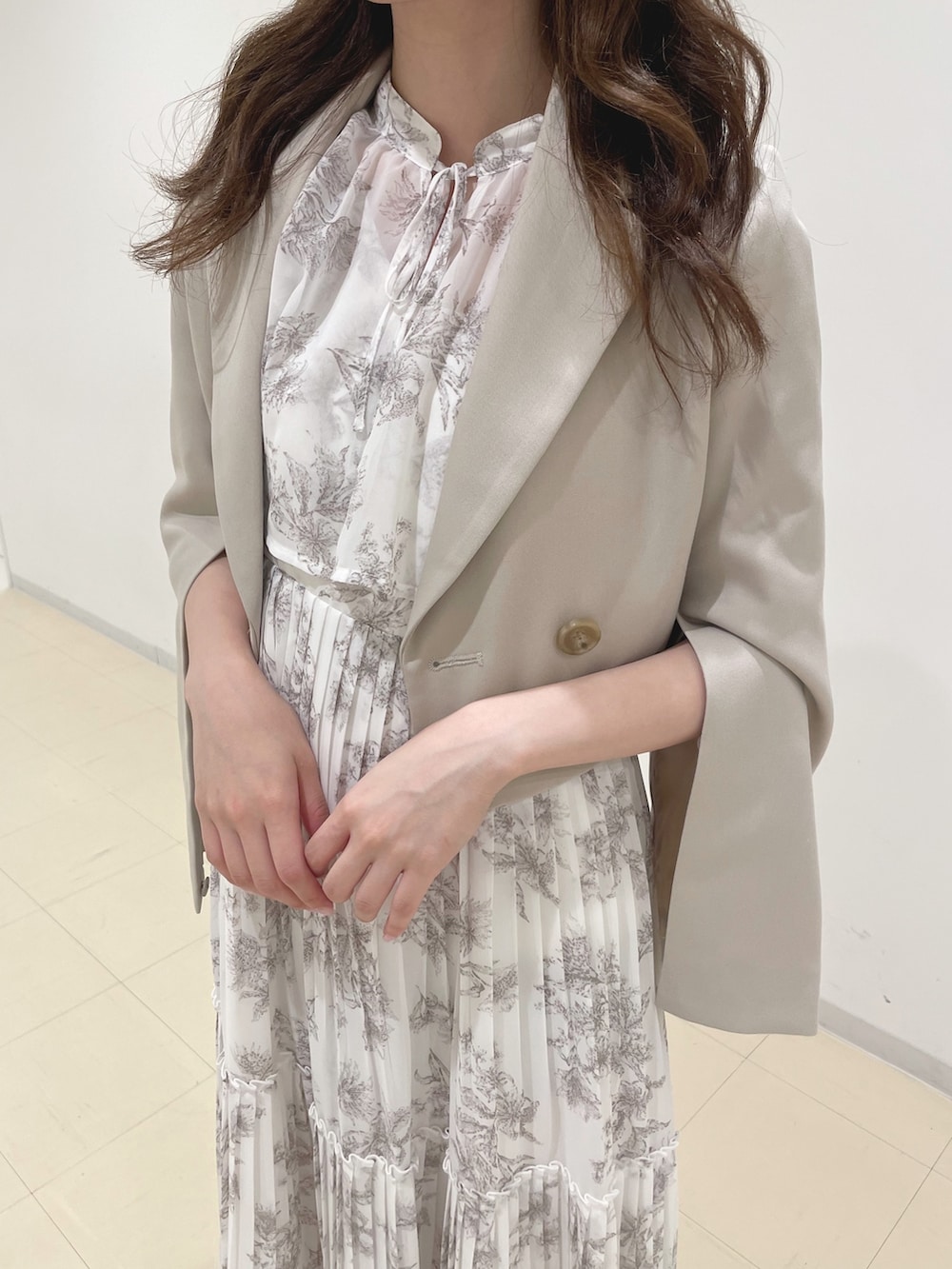 ベージュ系のワンピース、ベージュ系のテーラードジャケット、ベージュ系のブーツを着用したレディースの秋コーディネートの6枚目の写真