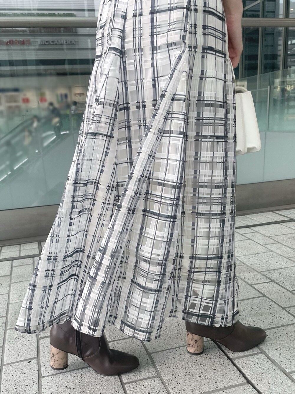 ホワイト系のショルダーバッグ、グレー系のニット/セーター、ホワイト系のチェスターコートを着用したレディースの冬コーディネートの7枚目の写真