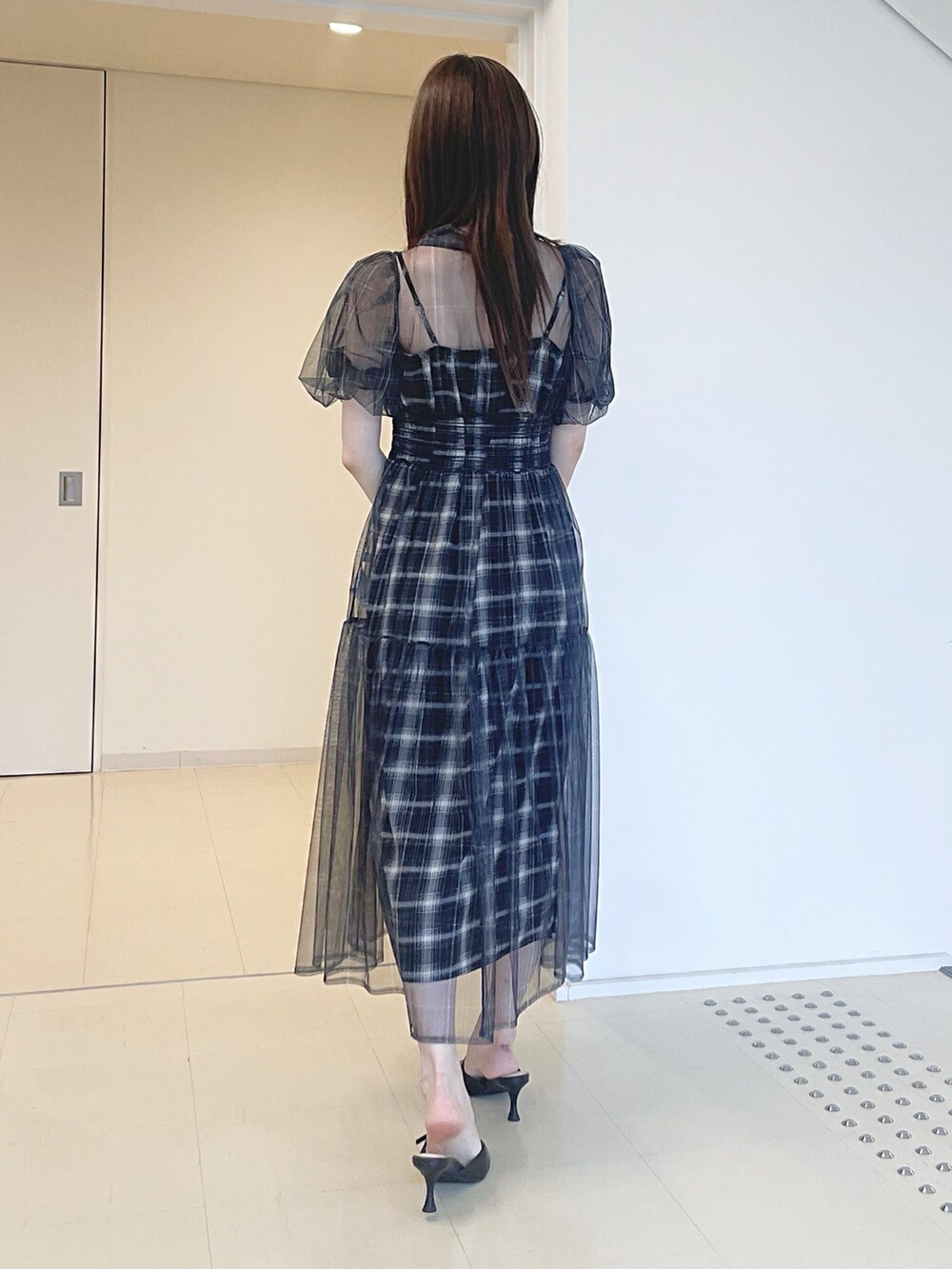 ブラック系のワンピース、ブラック系のショルダーバッグ、ブラック系のパンプスを着用したレディースの夏コーディネートの3枚目の写真