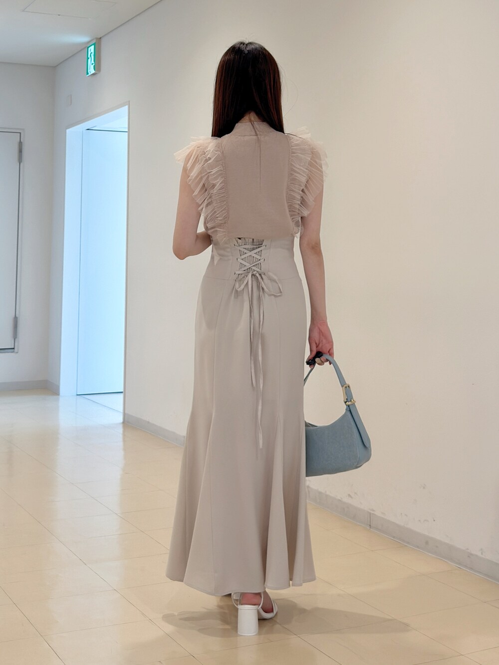 ピンク系のニット/セーター、ホワイト系のスカート、ブルー系のショルダーバッグを着用したレディースの春コーディネートの6枚目の写真