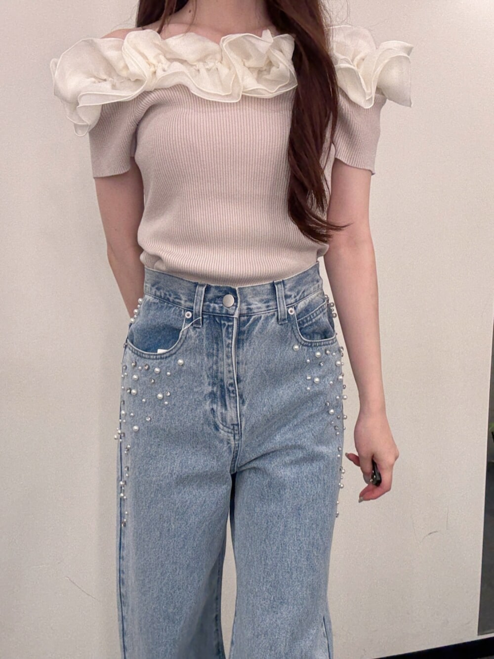 ブラウン系のハンドバッグ、ブルー系のデニムパンツ、ホワイト系のサンダルを着用したレディースの夏コーディネートの5枚目の写真