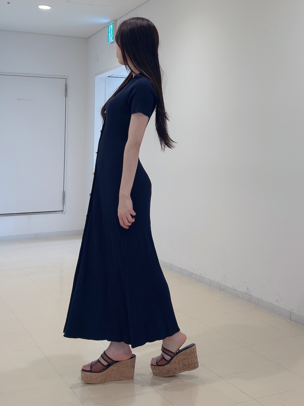 ブラック系のワンピース、ブラウン系のサンダルを着用したレディースの春コーディネートの3枚目の写真