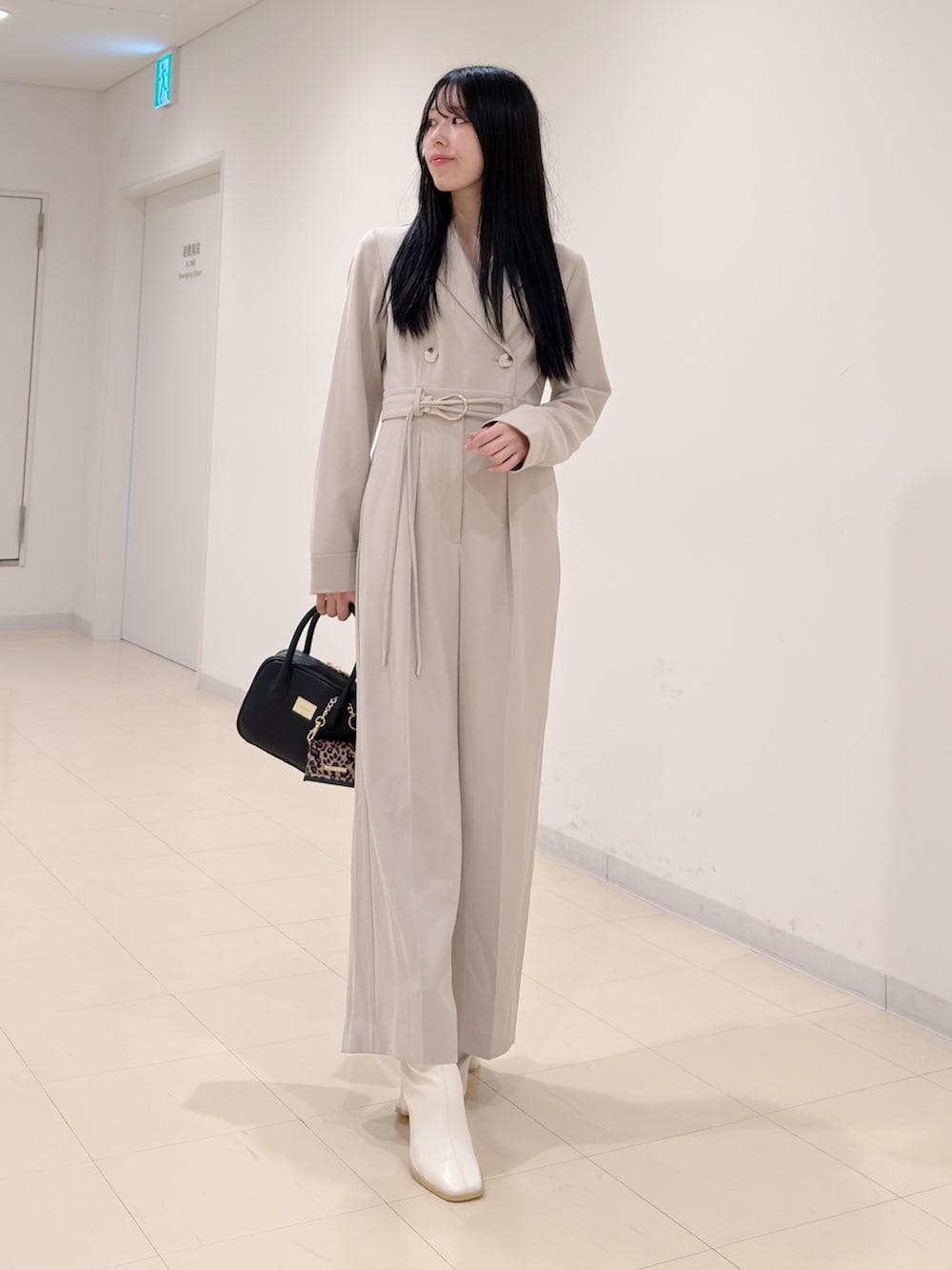 ベージュ系のつなぎ/オールインワン、ブラック系のハンドバッグ、ホワイト系のブーツを着用したレディースの秋コーディネートの5枚目の写真