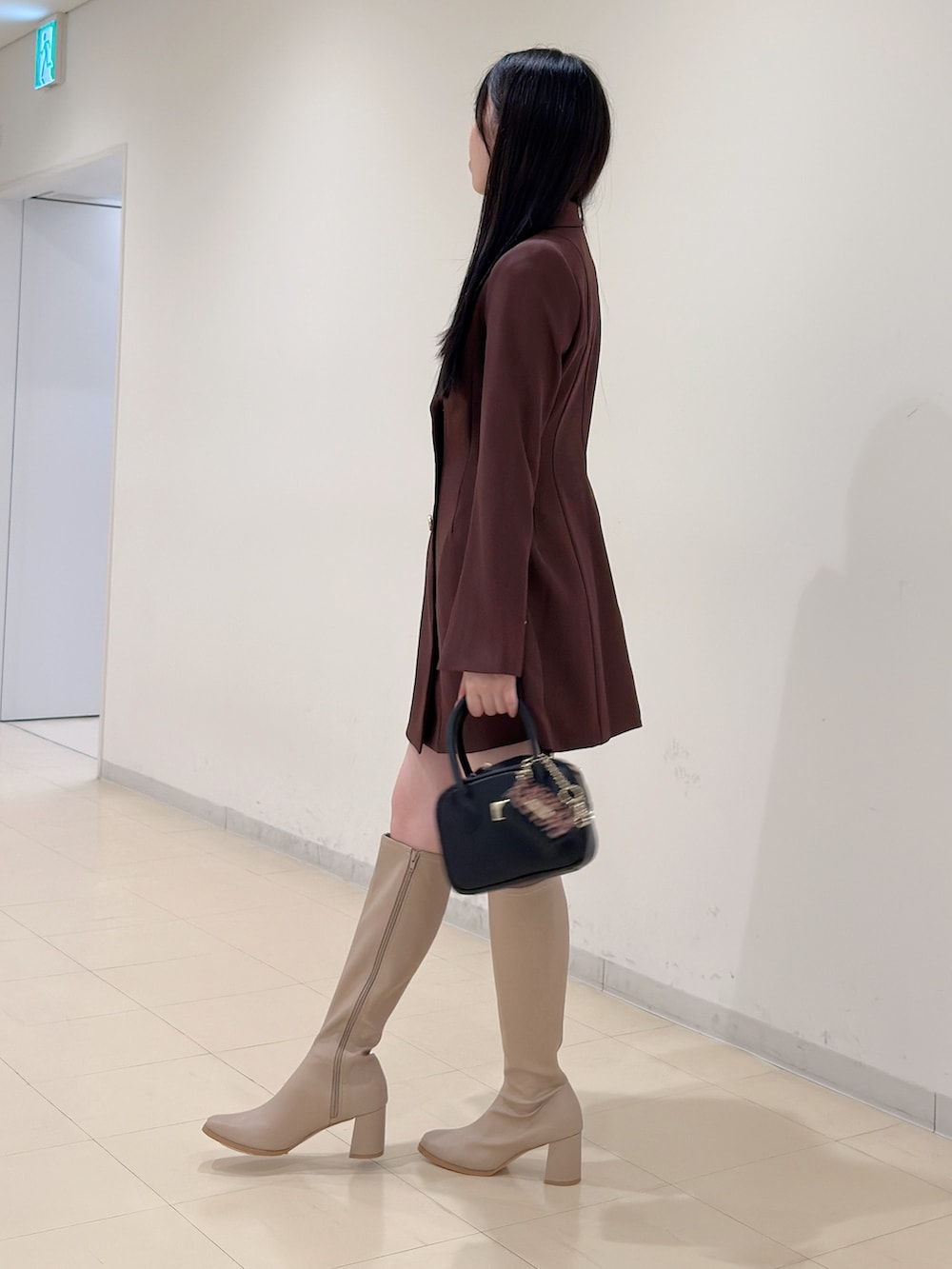 ベージュ系のブーツ、ブラウン系のワンピース、ブラック系のハンドバッグを着用したレディースの夏コーディネートの5枚目の写真