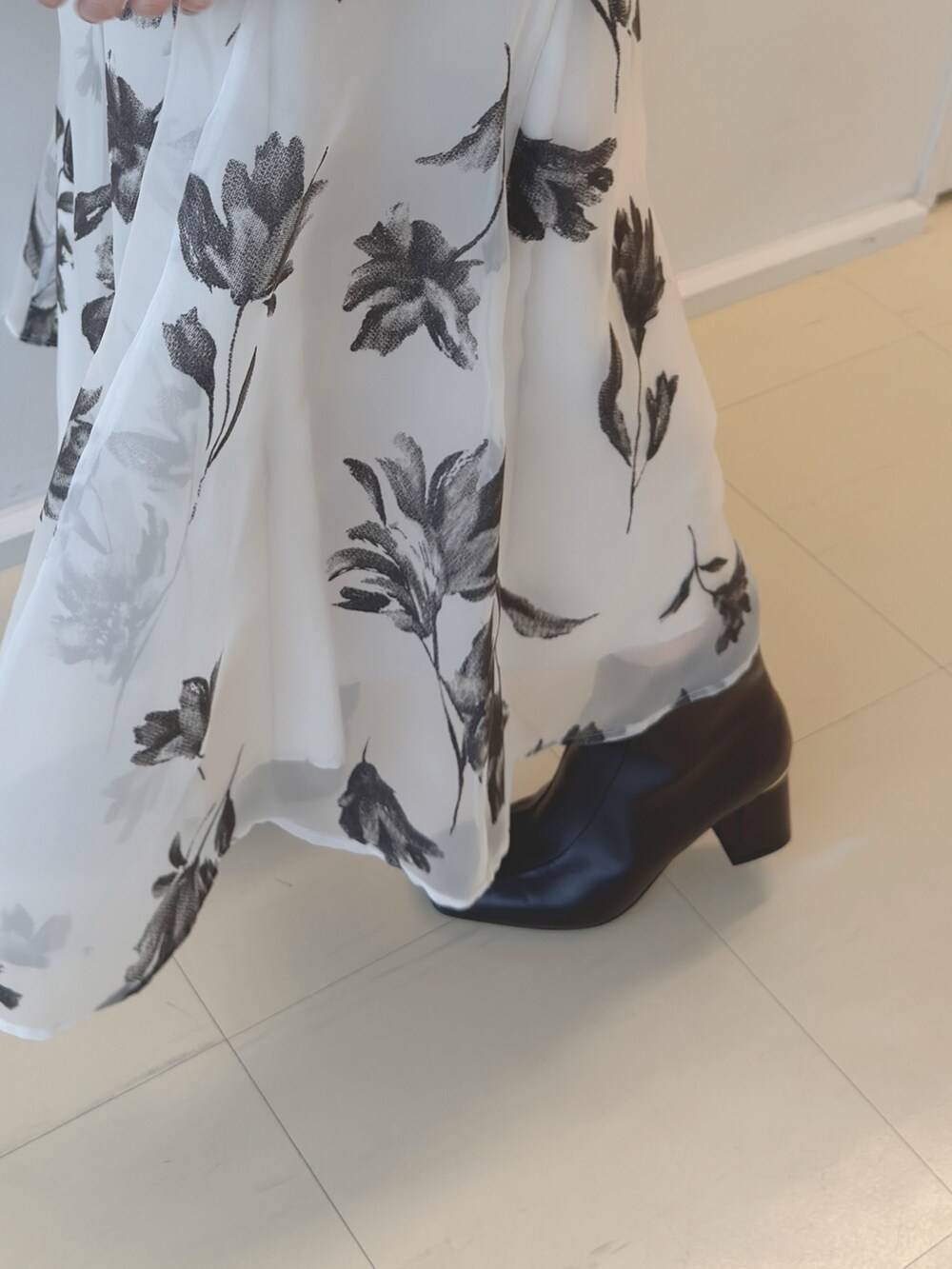 ホワイト系のニット/セーター、ホワイト系のスカート、ホワイト系のショルダーバッグを着用したレディースの秋コーディネートの6枚目の写真