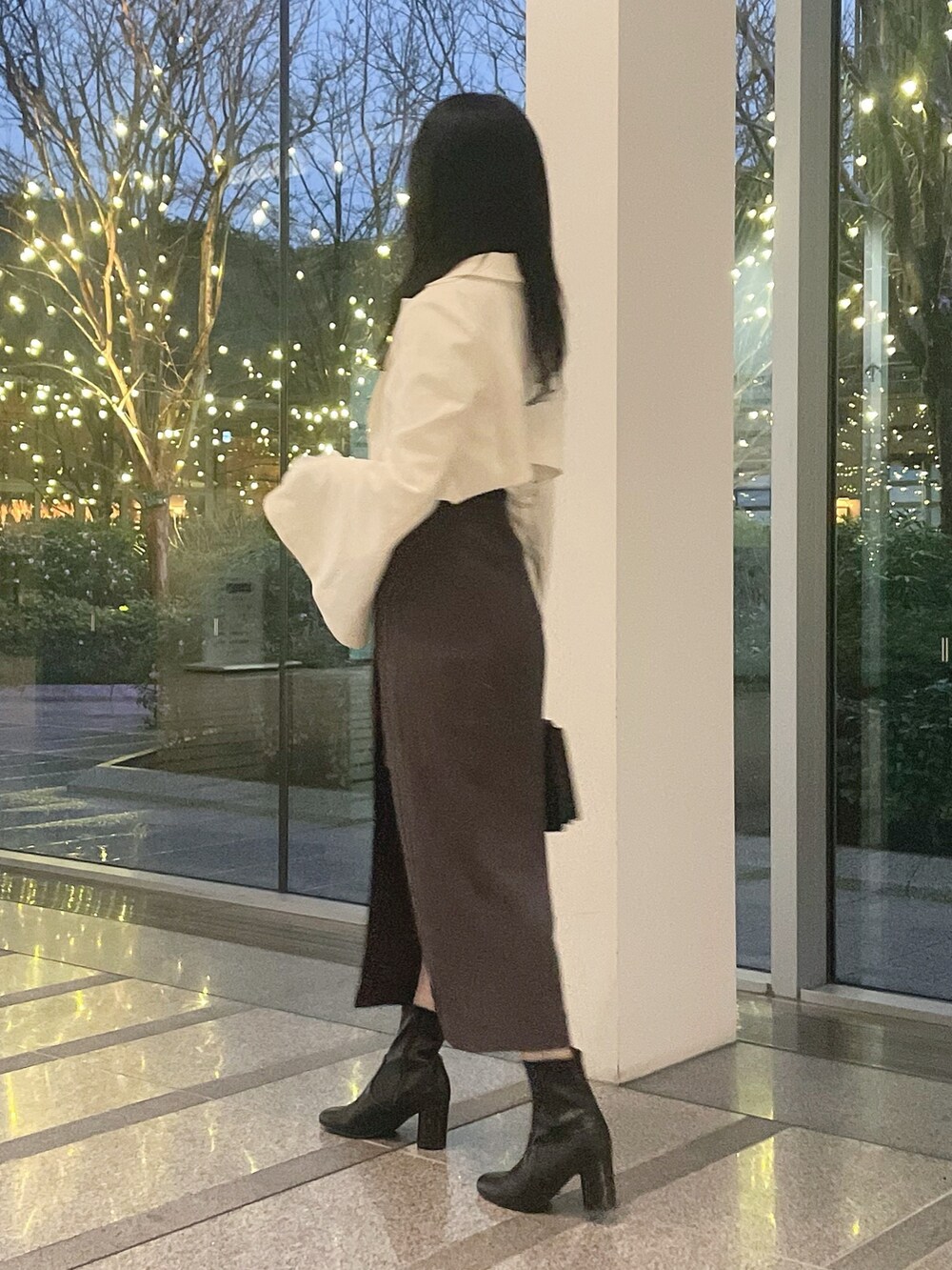 ホワイト系のテーラードジャケット、ホワイト系のニット/セーター、グレー系のスカートを着用したレディースの冬コーディネートの4枚目の写真