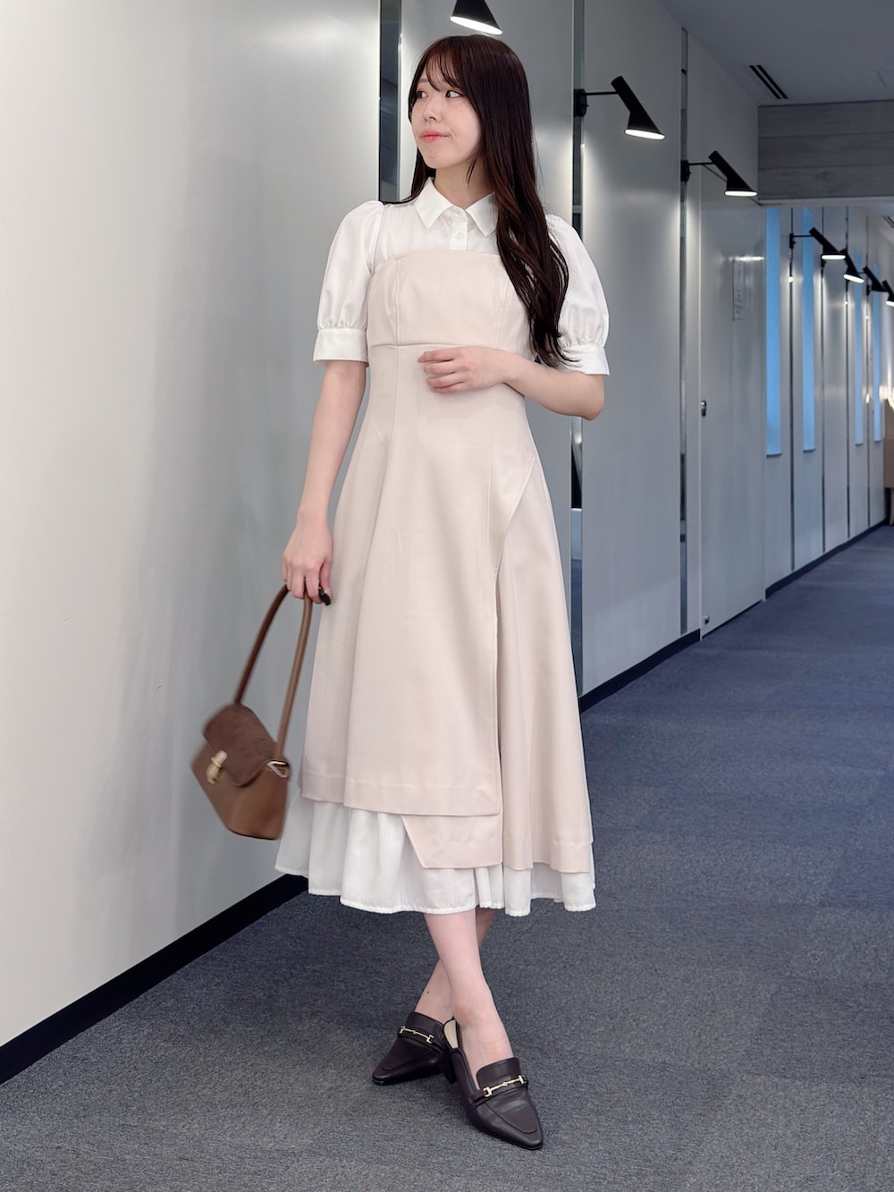 ベージュ系のワンピース、ブラウン系のハンドバッグ、ブラウン系のパンプスを着用したレディースの春コーディネートの5枚目の写真