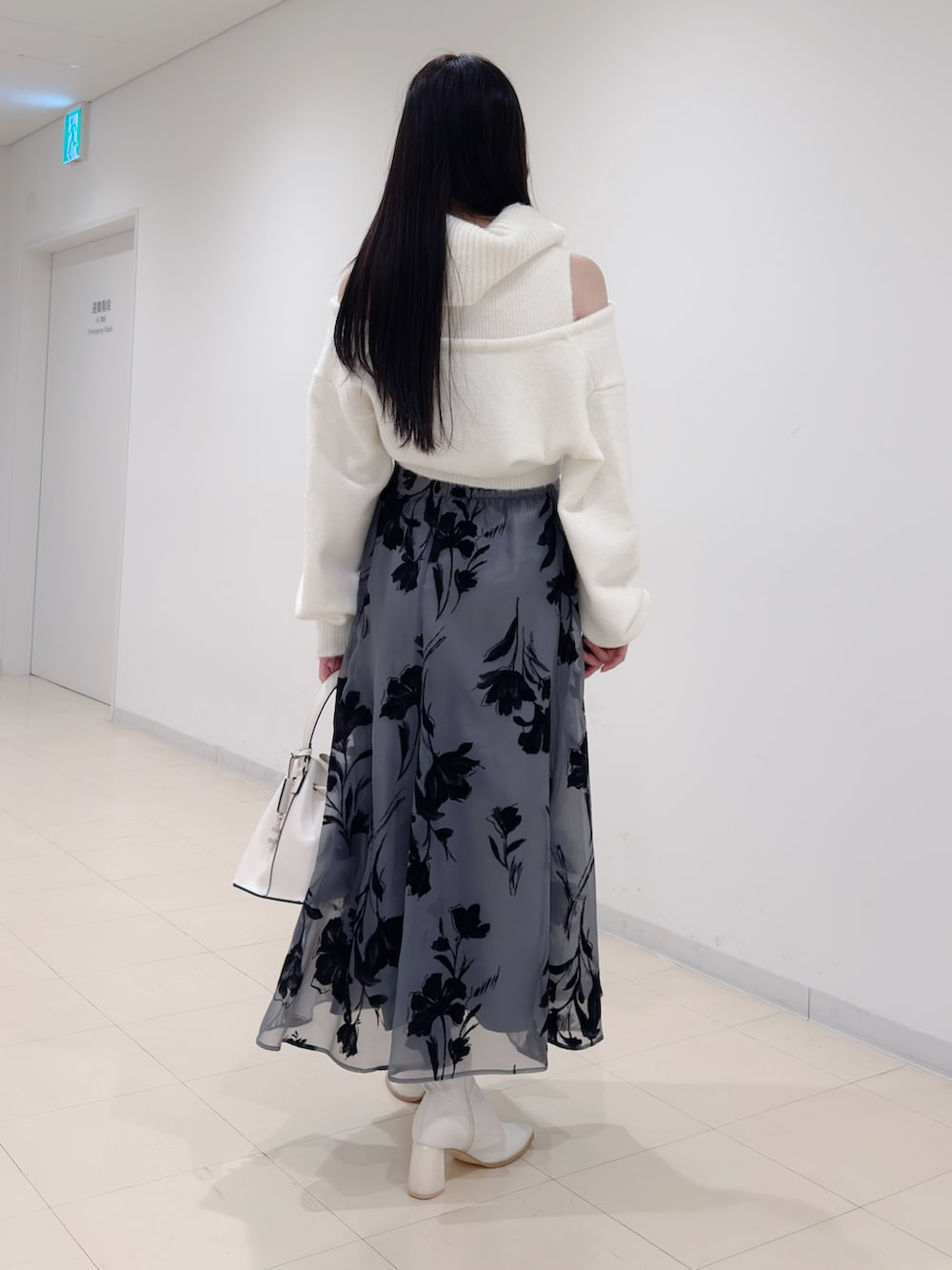 ホワイト系のニット/セーター、ブラック系のスカート、ホワイト系のショルダーバッグを着用したレディースの冬コーディネートの4枚目の写真