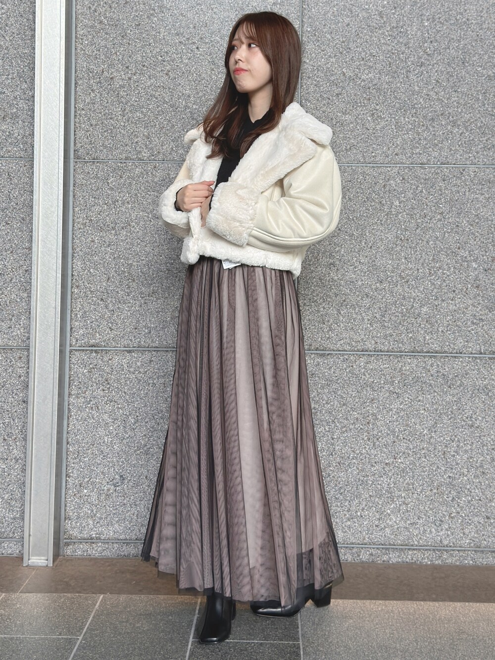 ホワイト系のムートンコート、ブラック系のワンピース、ブラック系のブーツを着用したレディースの秋コーディネートの2枚目の写真