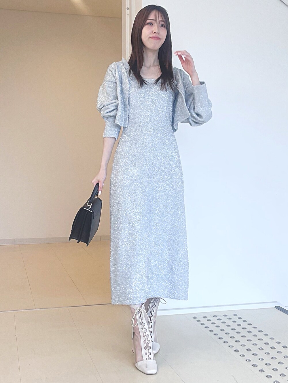 ホワイト系のブーツ、ブラック系のハンドバッグ、シルバー系のワンピースを着用したレディースの秋コーディネートの4枚目の写真