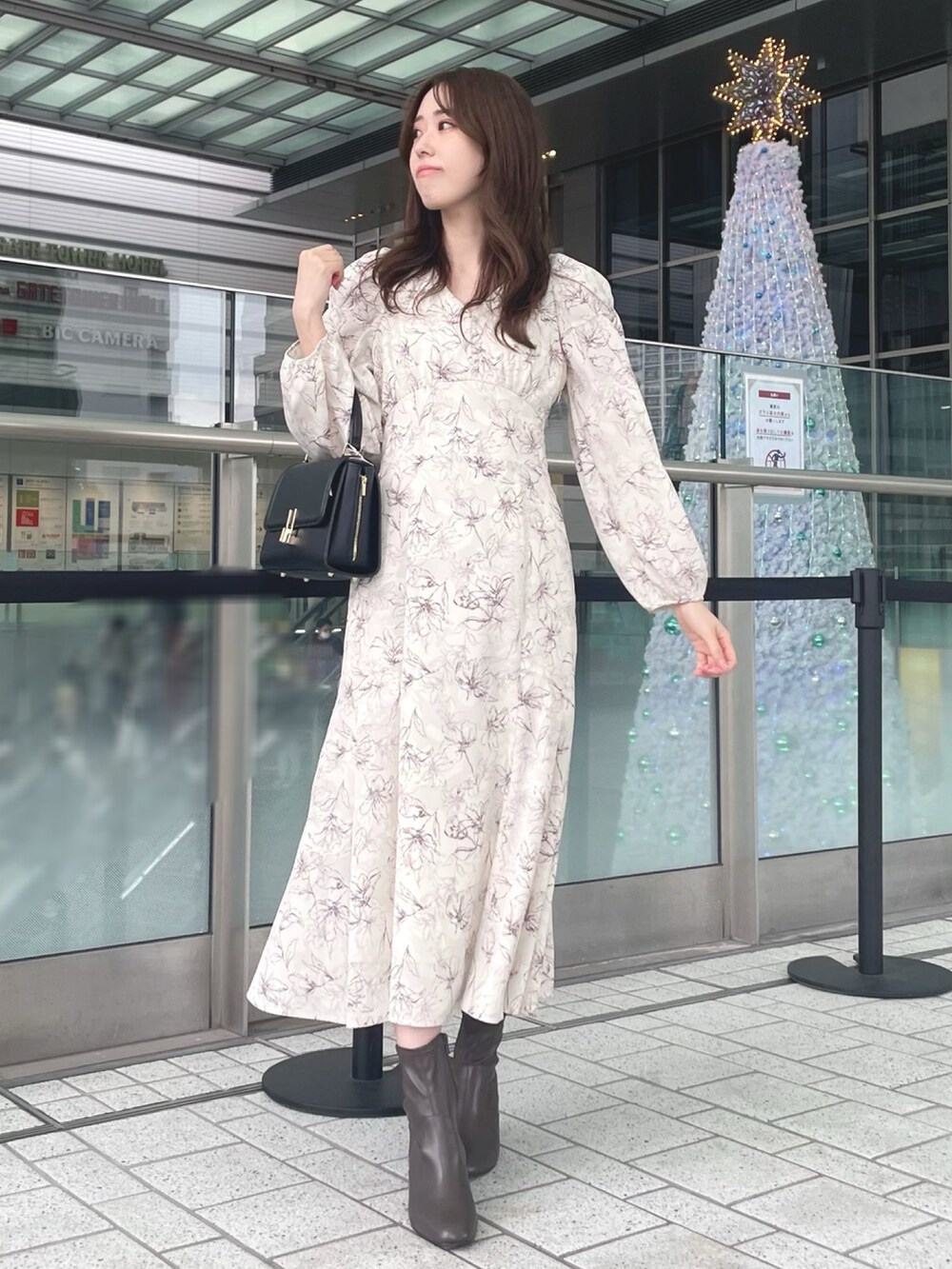 ホワイト系のカーディガン/ボレロ、ホワイト系のワンピース、ブラック系のショルダーバッグを着用したレディースの秋コーディネートの5枚目の写真