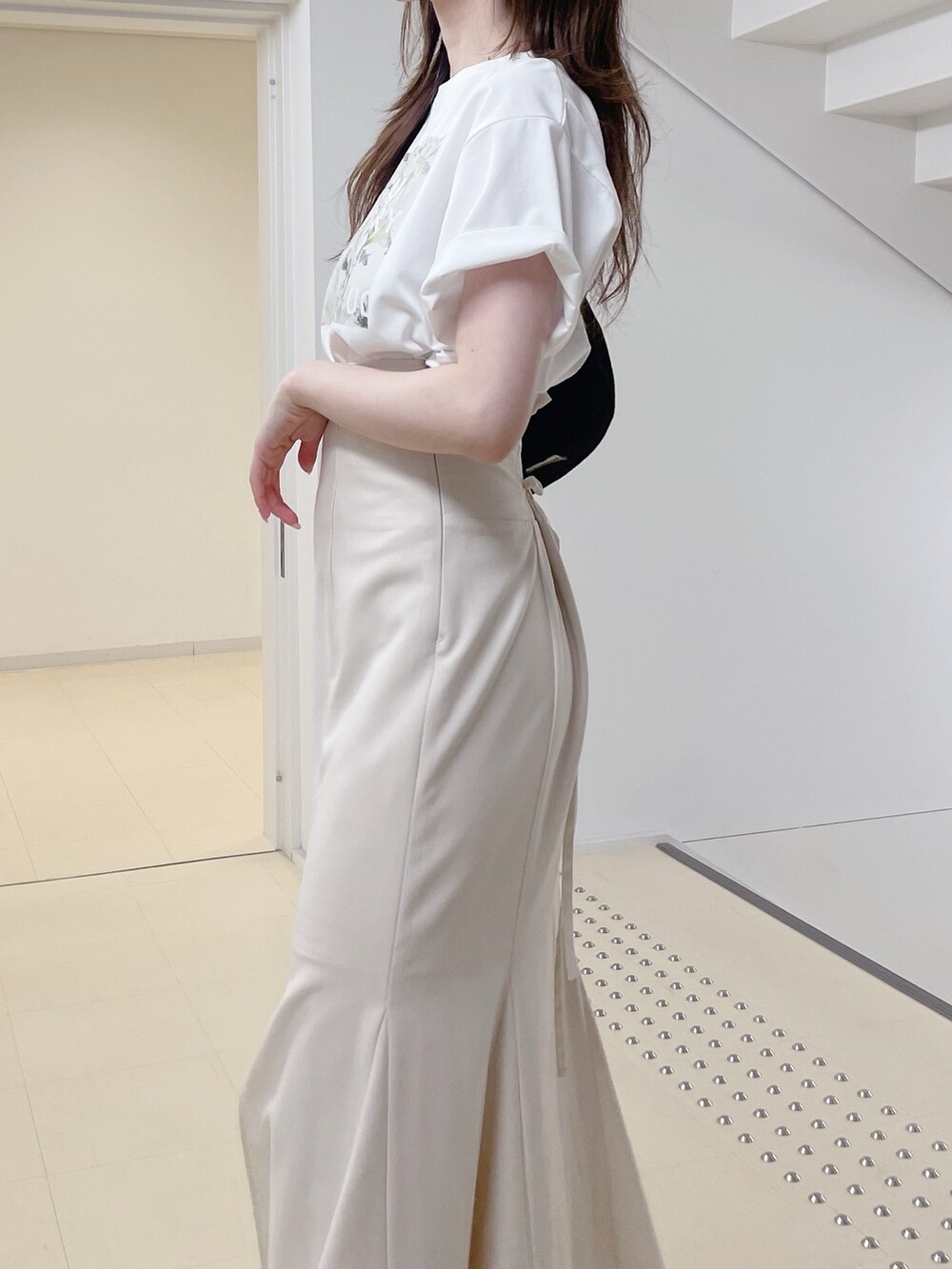 ホワイト系のTシャツ/カットソー、ホワイト系のスカート、ブラック系のショルダーバッグを着用したレディースの夏コーディネートの5枚目の写真