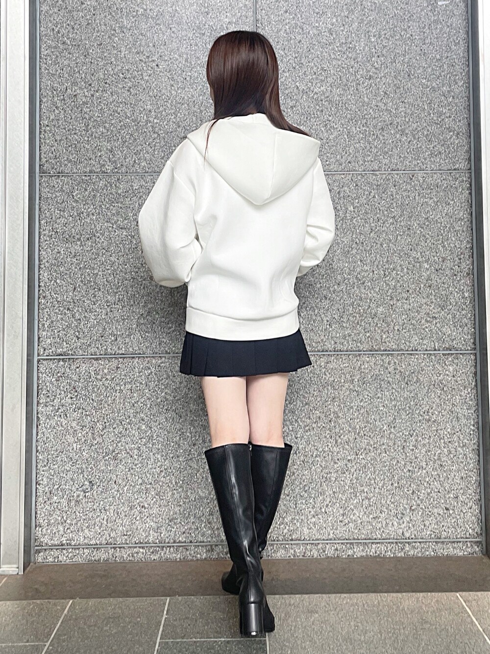 ホワイト系のパーカー、ブラック系のその他パンツ、ブラック系のブーツを着用したレディースの秋コーディネートの6枚目の写真