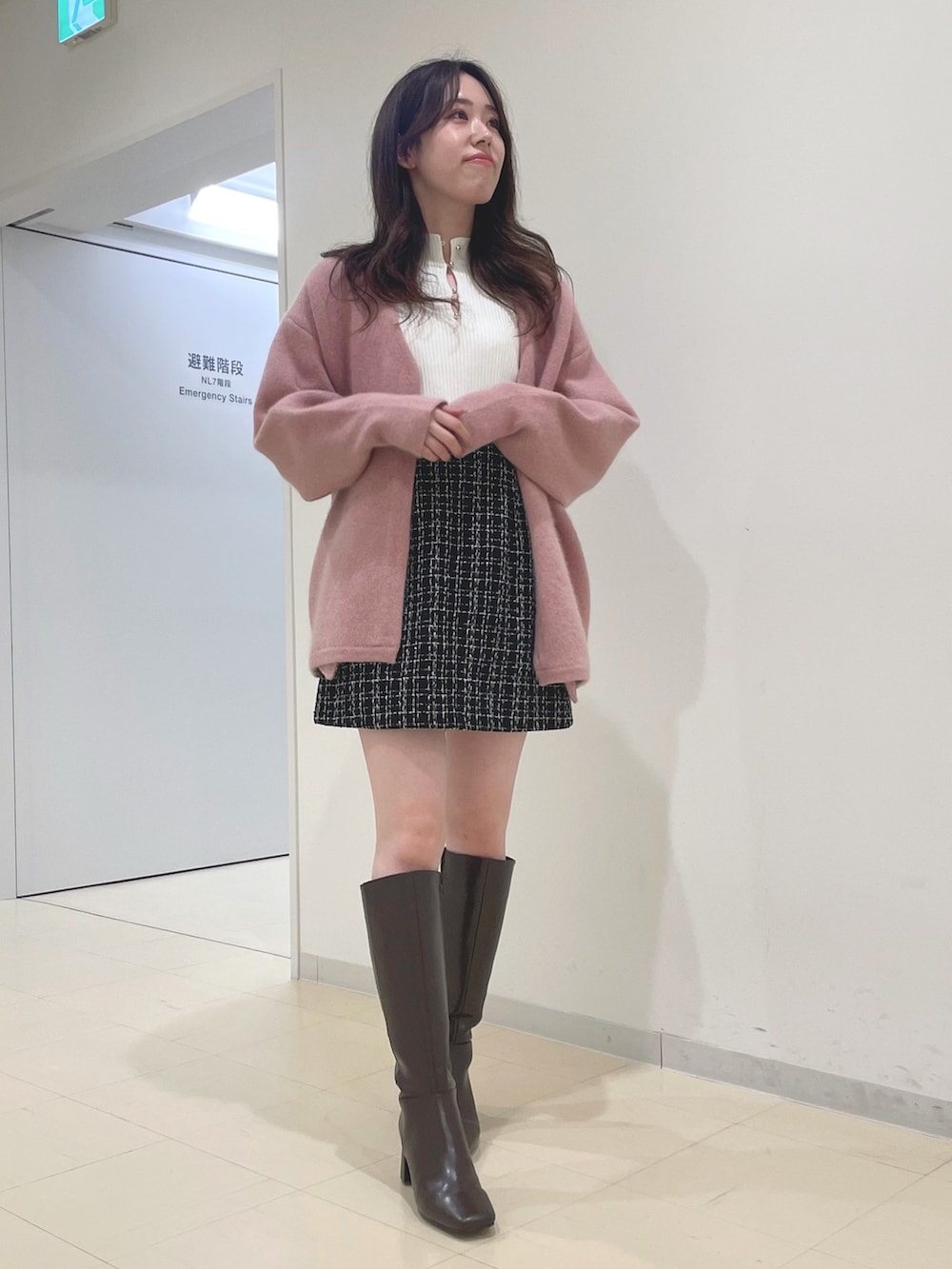 ブラック系のスカート、ホワイト系のニット/セーター、ピンク系のカーディガン/ボレロを着用したレディースの秋コーディネートの3枚目の写真