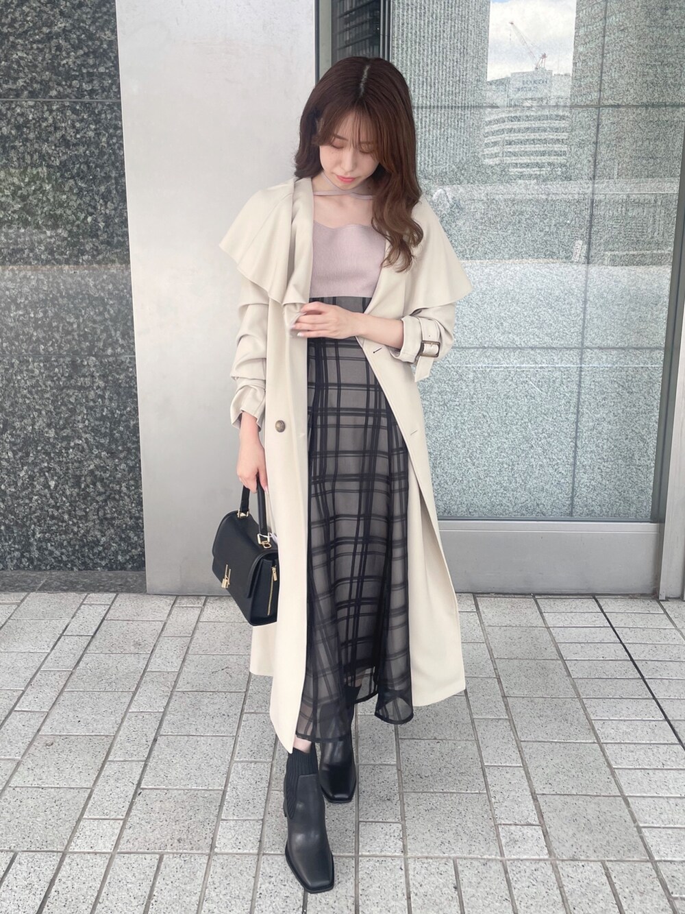 ピンク系のワンピース、ベージュ系のトレンチコート、ブラック系のショルダーバッグを着用したレディースの秋コーディネートの4枚目の写真