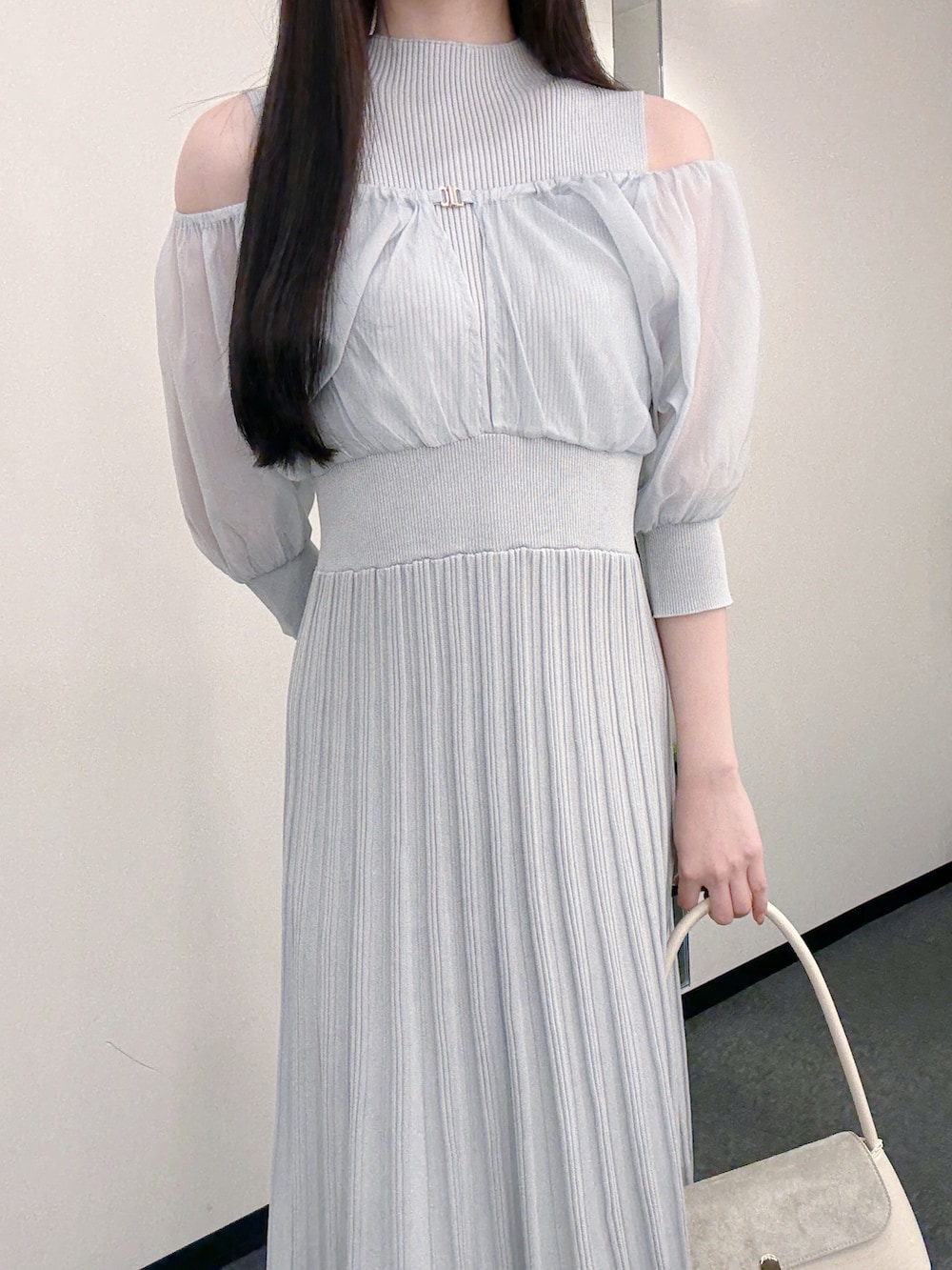 グレー系のワンピース、ホワイト系のハンドバッグ、ホワイト系のパンプスを着用したレディースの春コーディネートの6枚目の写真