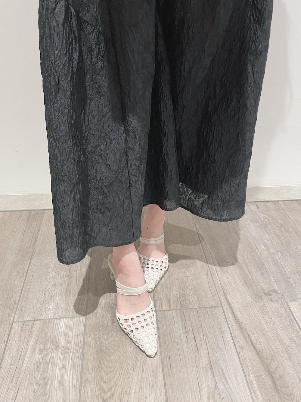 ブラック系のスカート、ホワイト系のパンプス、ホワイト系のカーディガン/ボレロを着用したレディースの冬コーディネートの7枚目の写真