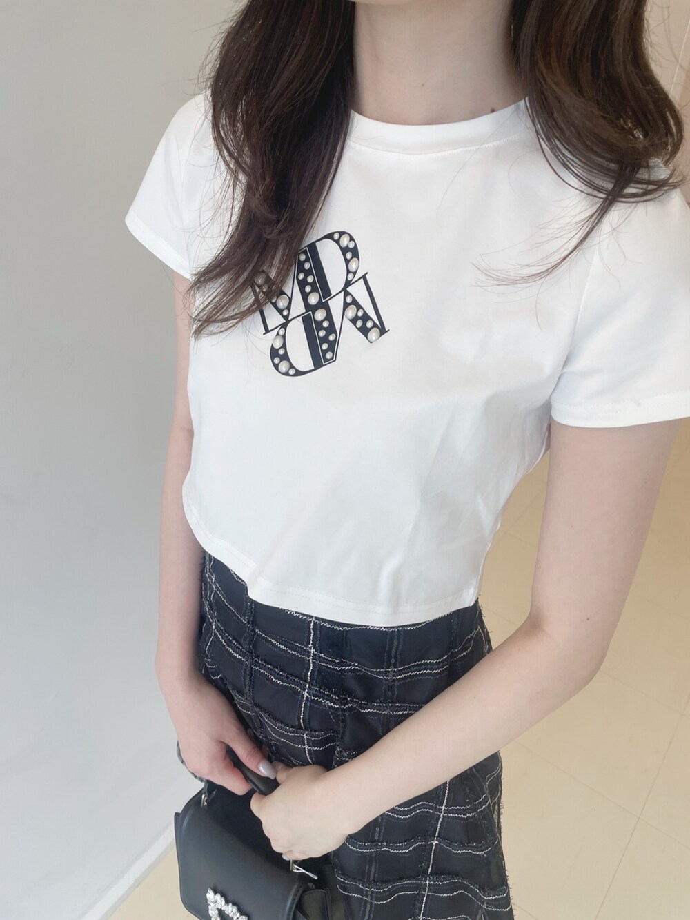 ホワイト系のTシャツ/カットソー、ブラック系のその他パンツ、ブラック系のショルダーバッグを着用したレディースの春コーディネートの6枚目の写真