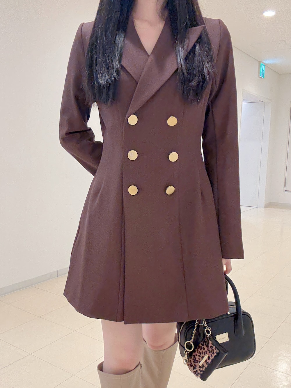 ベージュ系のブーツ、ブラウン系のワンピース、ブラック系のハンドバッグを着用したレディースの夏コーディネートの7枚目の写真