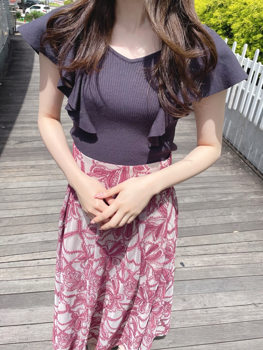 レッド系のスカート、グレー系のニット/セーター、ホワイト系のボストンバッグを着用したレディースの春コーディネートの5枚目の写真