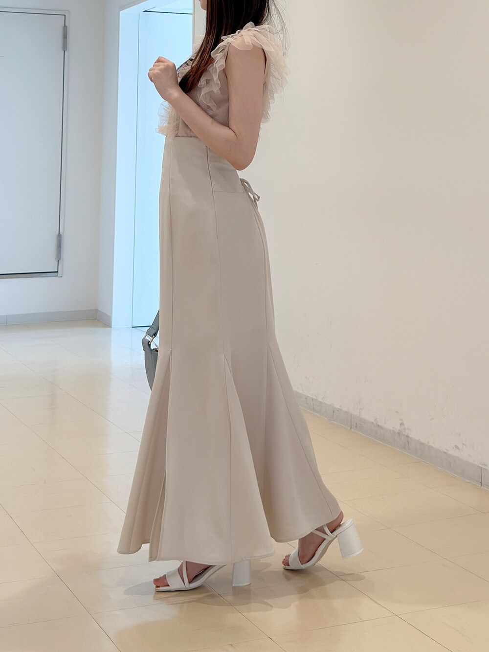 ピンク系のニット/セーター、ホワイト系のスカート、ブルー系のショルダーバッグを着用したレディースの春コーディネートの5枚目の写真