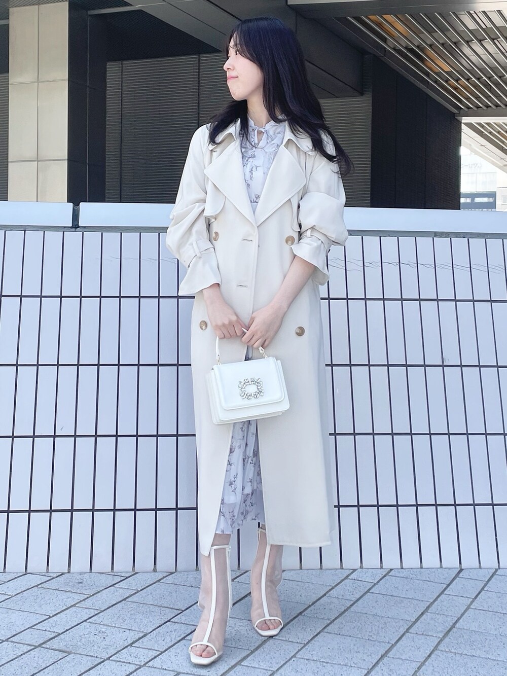 ホワイト系のトレンチコート、グレー系のワンピース、ホワイト系のブーツを着用したレディースの春コーディネートの2枚目の写真