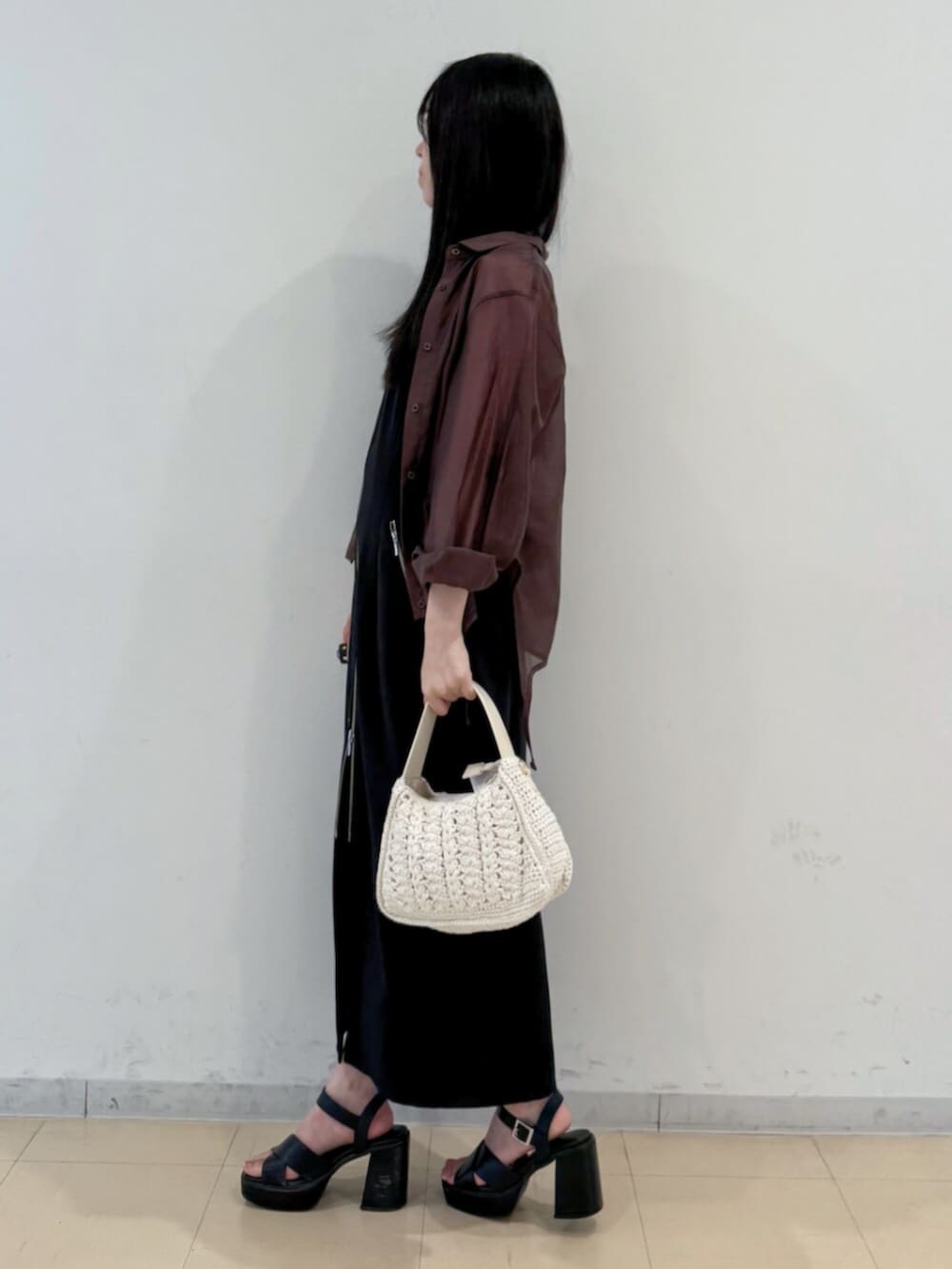 ブラック系のサンダル、ホワイト系のショルダーバッグ、ブラック系のワンピースを着用したレディースの夏コーディネートの3枚目の写真