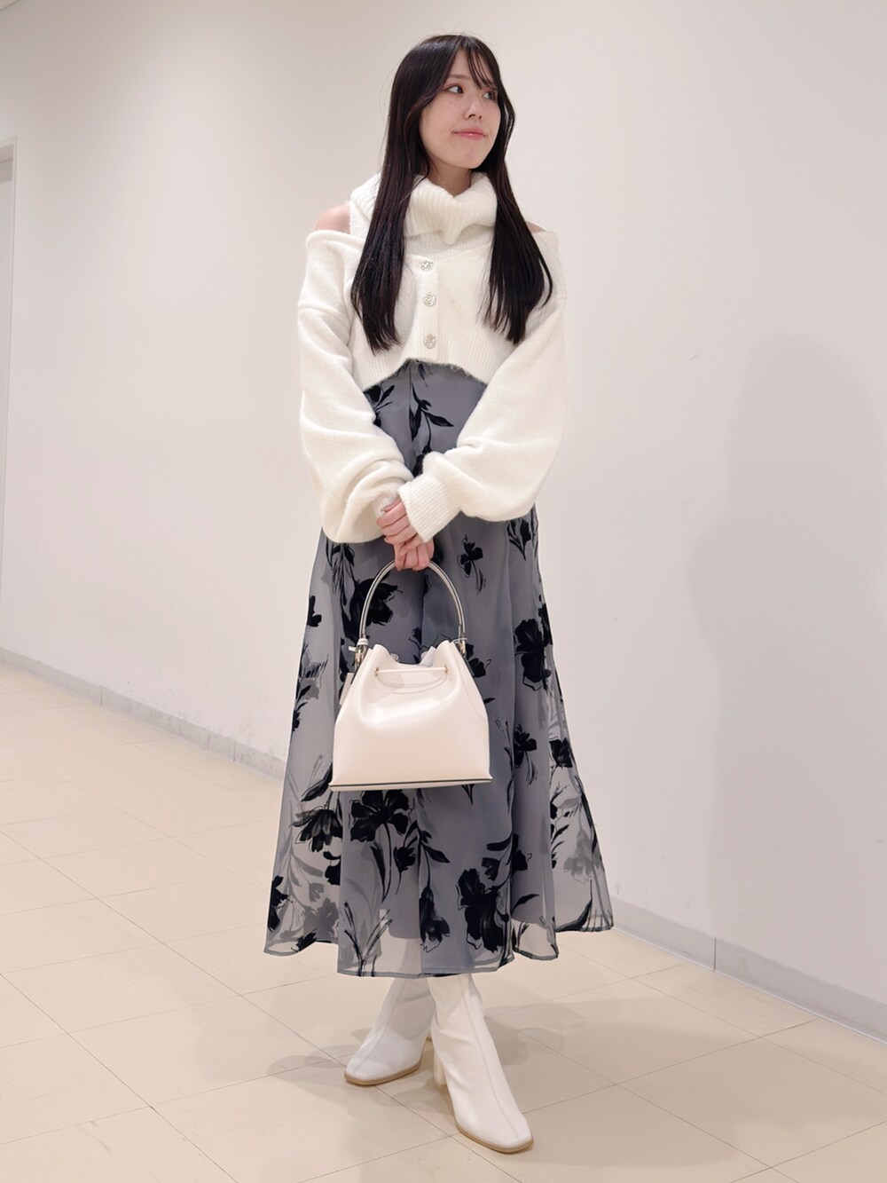 ホワイト系のニット/セーター、ブラック系のスカート、ホワイト系のショルダーバッグを着用したレディースの冬コーディネートの2枚目の写真
